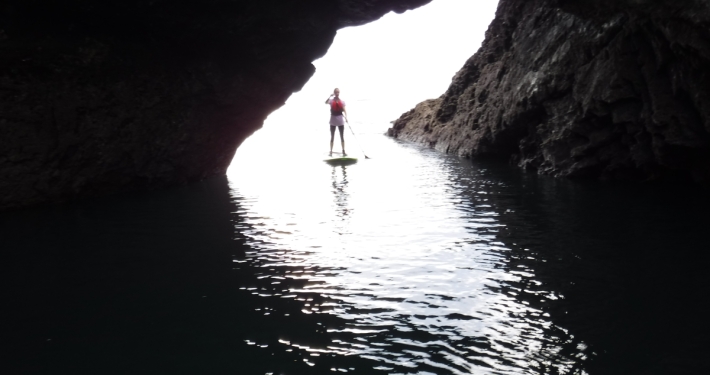 Girl on paddleboard near cave in Sligo Ireland
